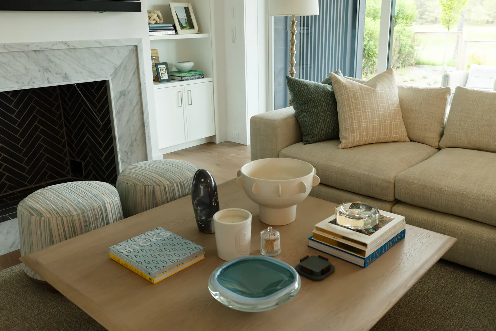 An oak coffee table layered with books and ceramics