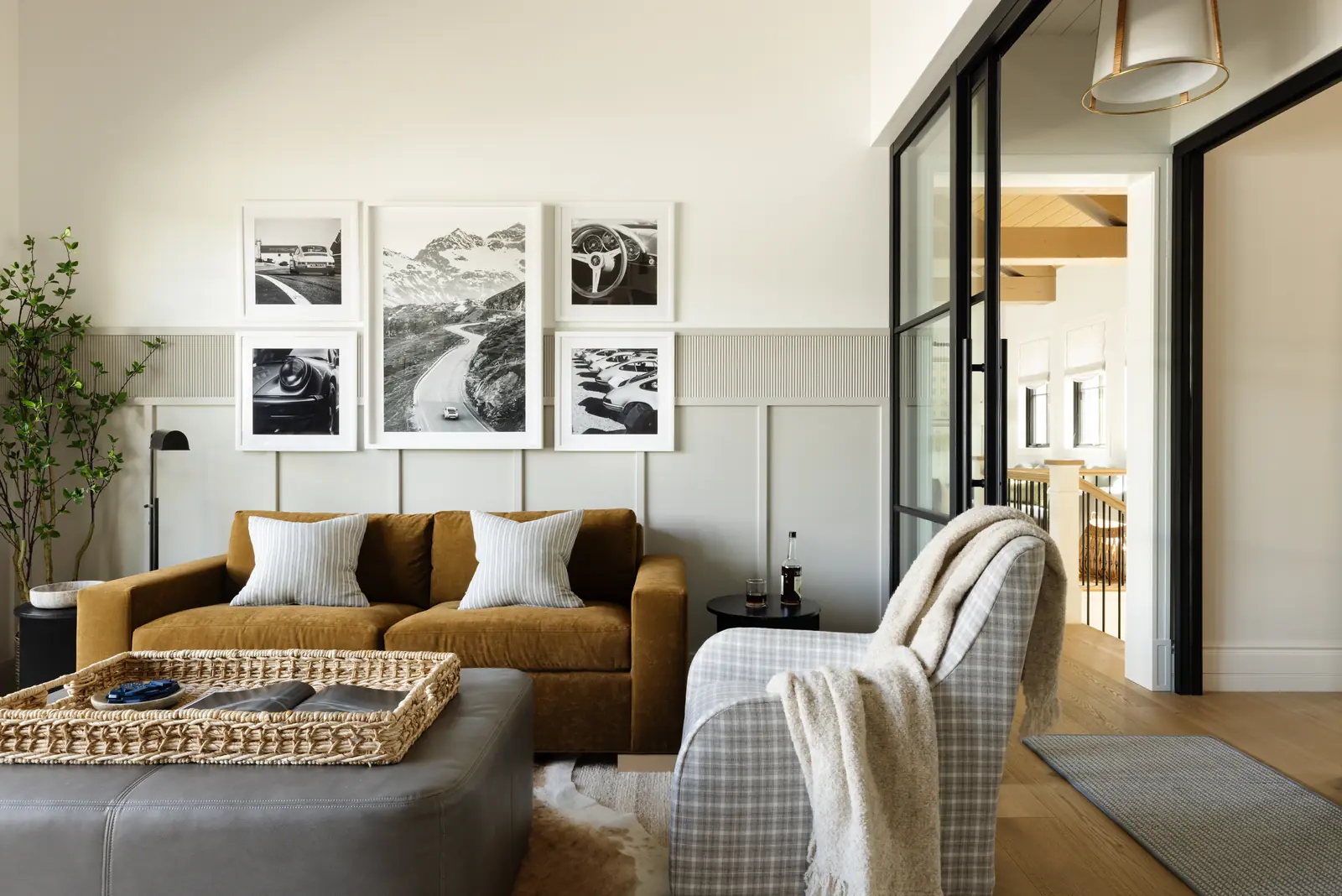 Den with a caramel sofa and black-and-white photography
